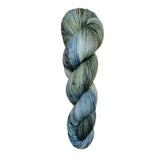 A skein of hand-dyed fingering/sock yarn color grey blue black speckles