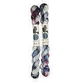 Two mini skeins of wool yarn hand dyed in Wyoming in the color white blue black red
