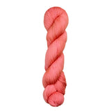 A skein of hand-dyed fingering/sock yarn color salmon pink