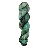 A skein of hand-dyed fingering/sock yarn color grey green black speckles