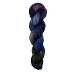 A skein of hand-dyed fingering/sock yarn color grey navy brown purple 