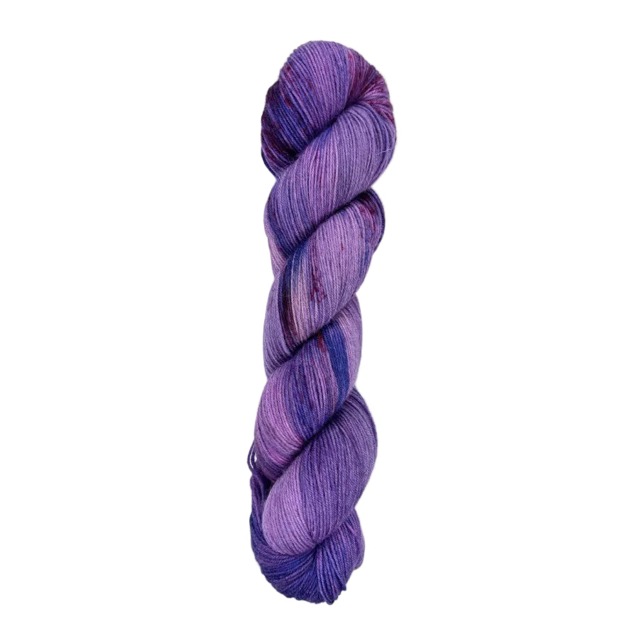 A skein of hand-dyed fingering/sock yarn color purple blue red speckles