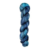 A skein of hand-dyed fingering/sock yarn color blue grey black speckles