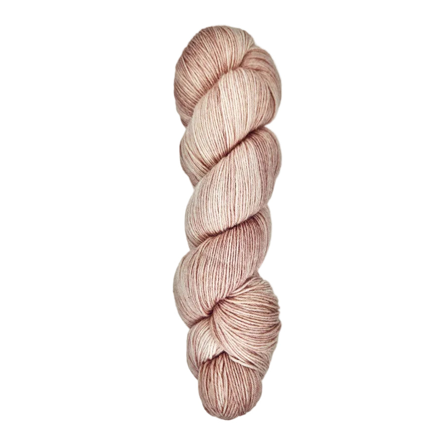A skein of hand-dyed fingering/sock yarn color dusty pink