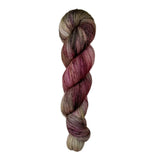 A skein of hand-dyed fingering/sock yarn color brown tan red speckles