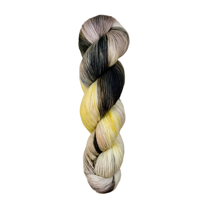 A skein of hand-dyed fingering/sock yarn color grey yellow peach mauve black