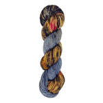 A skein of hand-dyed fingering/sock yarn color grey brown red black speckles