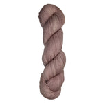 Skein of hand dyed fingering weight yarn in the color dusty rose