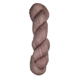 Skein of hand dyed fingering weight yarn in the color dusty rose