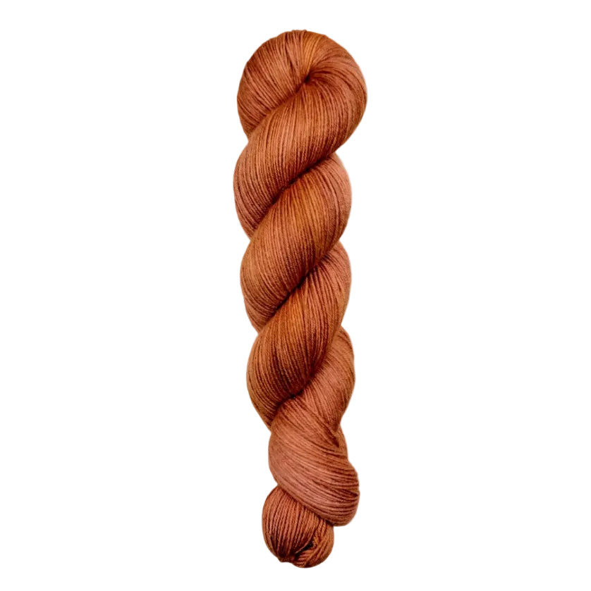 A skein of hand-dyed fingering/sock yarn color rust orange