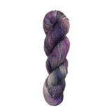 A single twisted skein of variegated yarn in shades of purple, violet, and gray