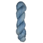 Skein of hand dyed fingering weight yarn in the color sky blue