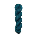 Teal skein of yarn  with speckles on a white background