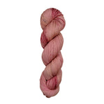 A skein of hand-dyed fingering/sock yarn color pink red brown speckles