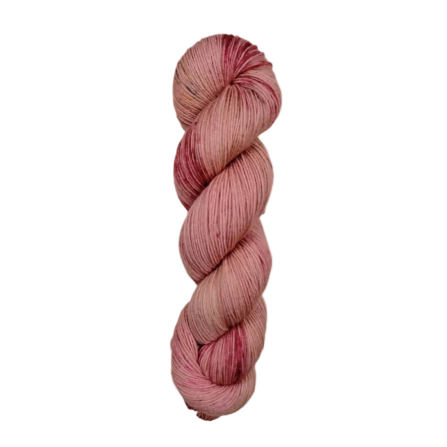 A skein of hand-dyed fingering/sock yarn color pink red brown speckles