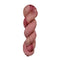 A skein of hand-dyed fingering/sock yarn color pink red brown speckles