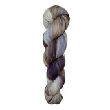 A skein of hand-dyed fingering/sock yarn color white grey tan blue brown