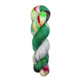 A skein of hand-dyed fingering/sock yarn color white yellow blue green red speckles