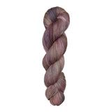 Fingering weight yarn skein with purple, pink, and brown tones on a white background