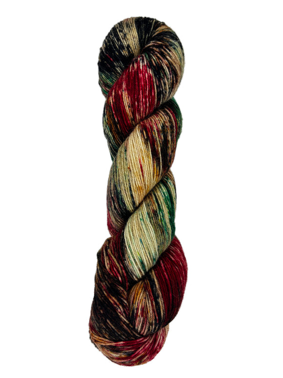 A skein of hand-dyed fingering/sock yarn color brown black red green speckles