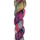 A skein of hand-dyed fingering/sock yarn color grey golden yellow red purple black speckles