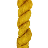 A skein of hand-dyed fingering/sock yarn color golden yellow