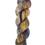 A skein of hand-dyed fingering/sock yarn color grey tan brown navy black speckles