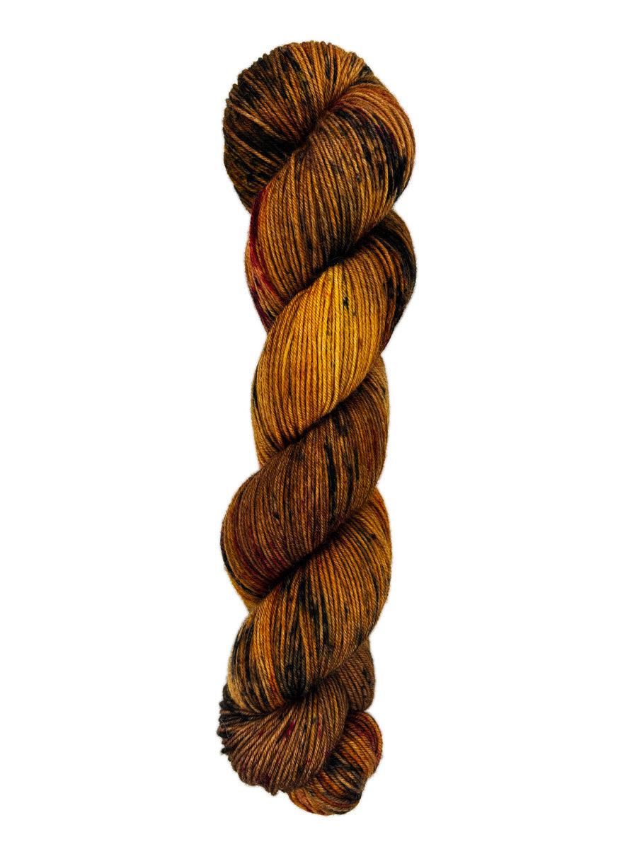 A skein of hand-dyed fingering/sock yarn color burnt orange brown black speckles