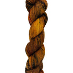 A skein of hand-dyed fingering/sock yarn color burnt orange brown black speckles
