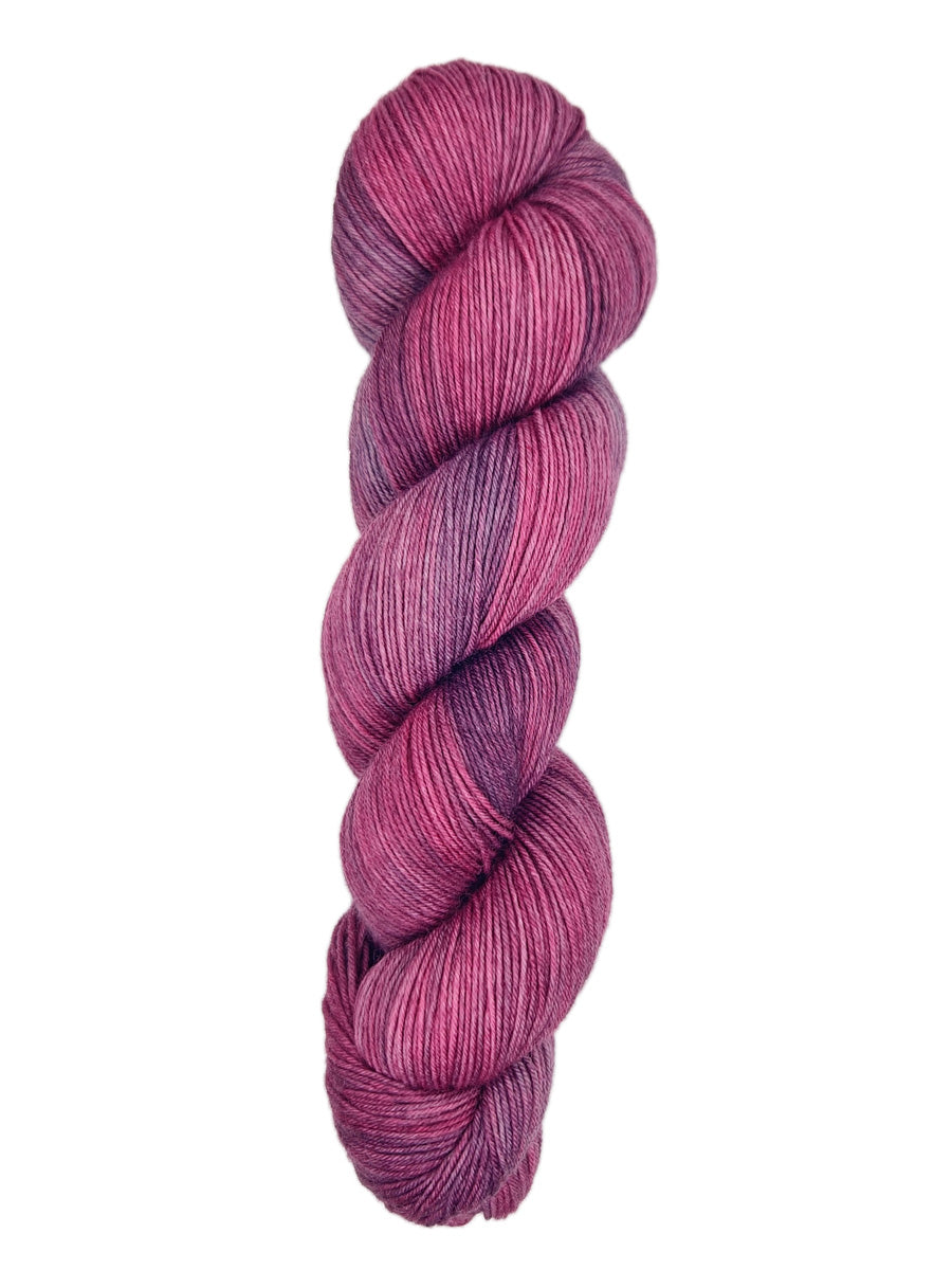 A skein of hand-dyed fingering/sock yarn color pink purple