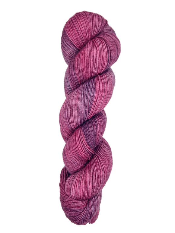 A skein of hand-dyed fingering/sock yarn color pink purple