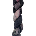 A skein of hand-dyed fingering/sock yarn color black mauve grey pink mild speckles