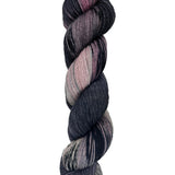 A skein of hand-dyed fingering/sock yarn color black mauve grey pink mild speckles