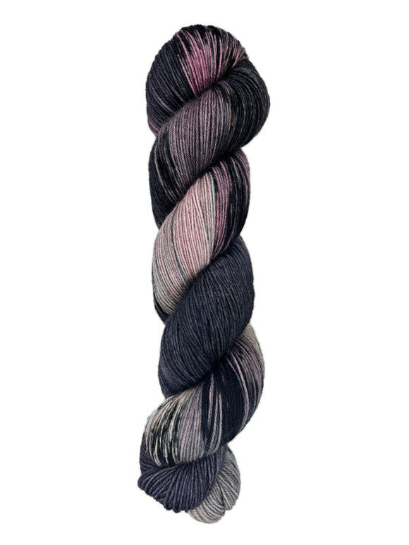 A skein of hand-dyed fingering/sock yarn color black mauve grey pink mild speckles