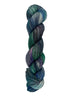 A skein of hand-dyed fingering/sock yarn color blue teal green purple grey