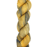 A skein of hand-dyed fingering/sock yarn color yellow tan navy black speckles