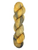 A skein of hand-dyed fingering/sock yarn color yellow tan navy black speckles