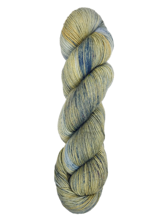 A skein of hand-dyed fingering/sock yarn color grey tan navy speckles