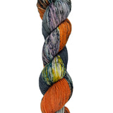 A skein of hand-dyed fingering/sock yarn color grey orange yellow dark green speckles