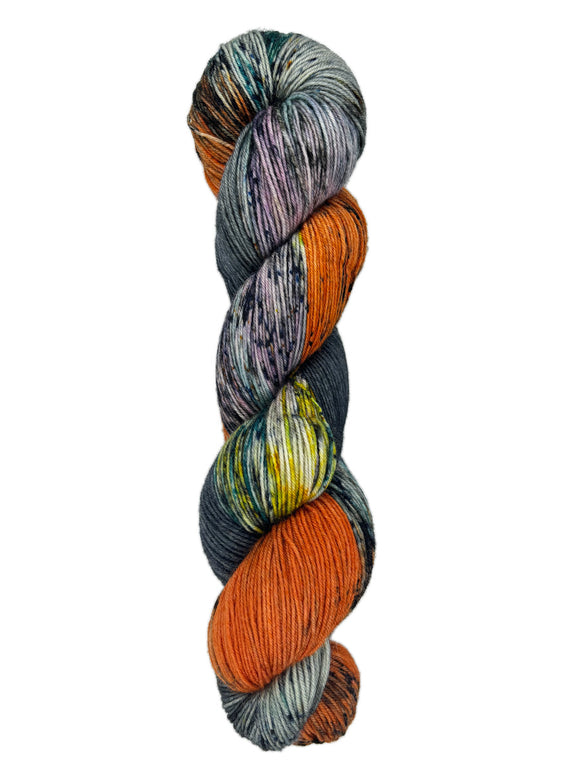 A skein of hand-dyed fingering/sock yarn color grey orange yellow dark green speckles