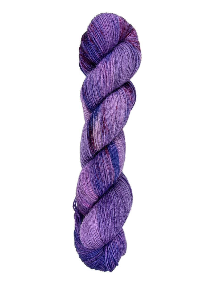 A skein of hand-dyed fingering/sock yarn color purple blue red speckles