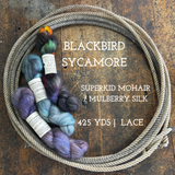 Skeins of mohair silk yarn of various colors on a wooden surface