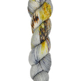 A skein of hand-dyed fingering/sock yarn color grey yellow orange brown speckles