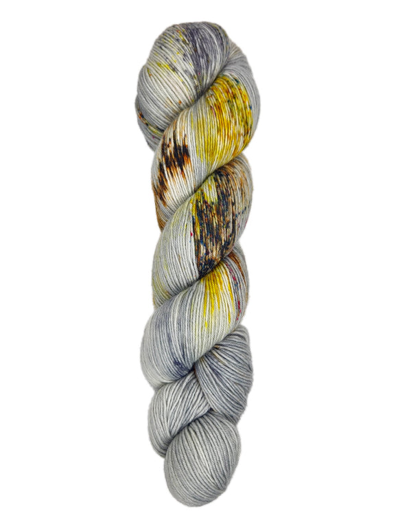 A skein of hand-dyed fingering/sock yarn color grey yellow orange brown speckles