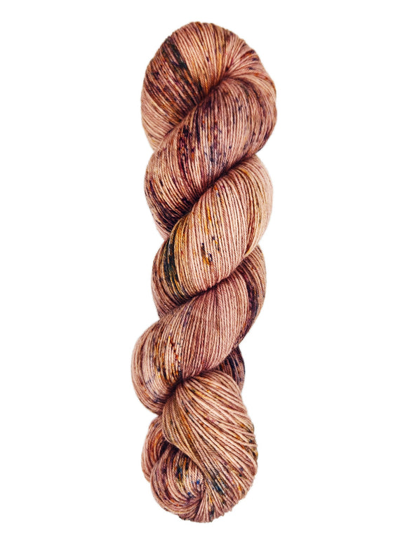 A skein of hand-dyed fingering/sock yarn color pink brown orange mauve speckles