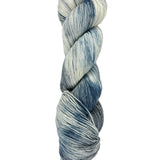 A skein of hand-dyed fingering/sock yarn color white grey blue mild speckling
