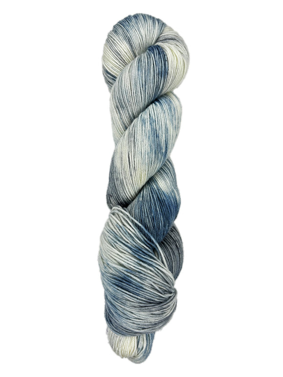 A skein of hand-dyed fingering/sock yarn color white grey blue mild speckling