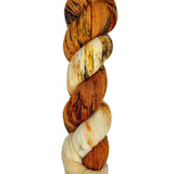 A skein of hand-dyed fingering/sock yarn color white orange red yellow black speckles