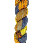 A skein of hand-dyed fingering/sock yarn color orange grey navy yellow black speckles