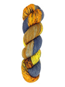 A skein of hand-dyed fingering/sock yarn color orange grey navy yellow black speckles